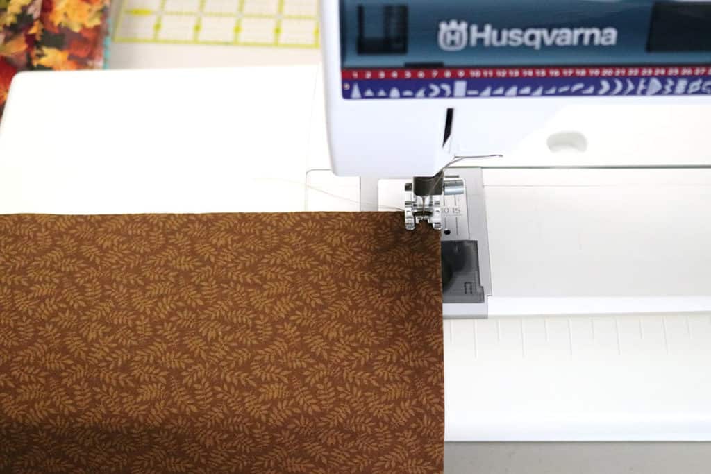 sewing brown fabric with machine