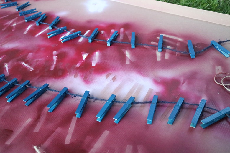 painting clothespins on a line for a clothespin wreath