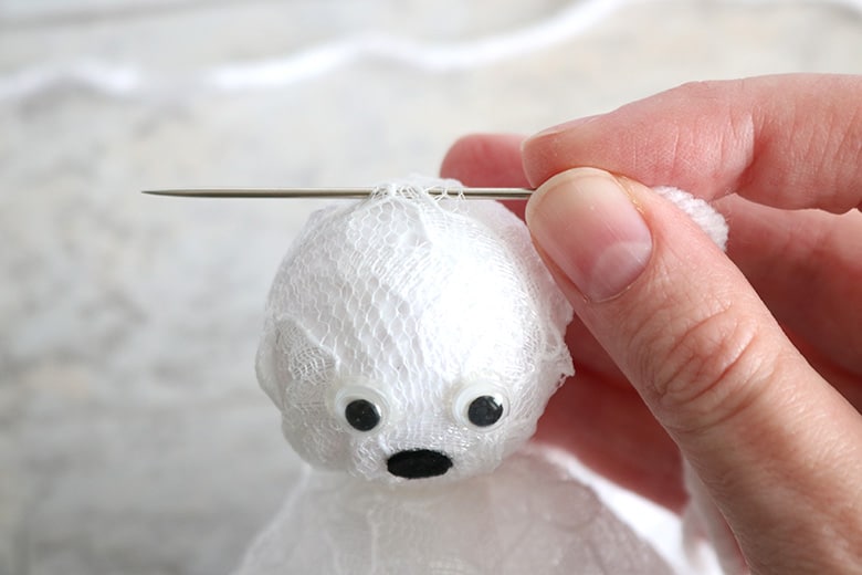 making a DIY ghost garland for Halloween from lace and plastic golf balls