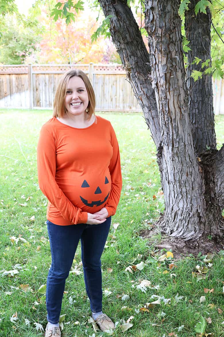 This pumpkin maternity shirt DIY is perfect for showing off your baby bump! All you need is a simple jack-o-lantern stencil and some fabric paint! Makes a great Halloween outfit or an easy pregnancy costume! 