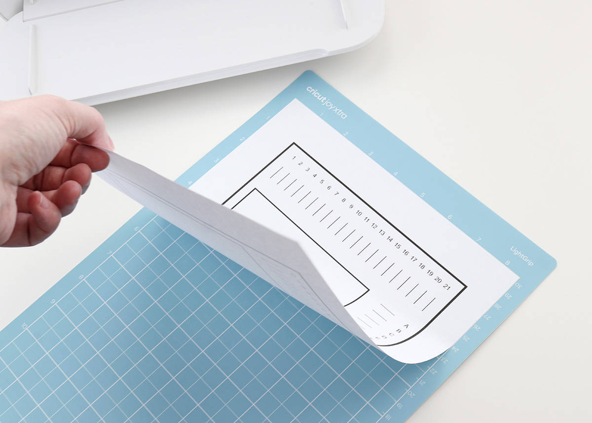 putting Cricut calibration sheet on LightGrip mat for Print Then Cut calibration of Cricut Joy Xtra