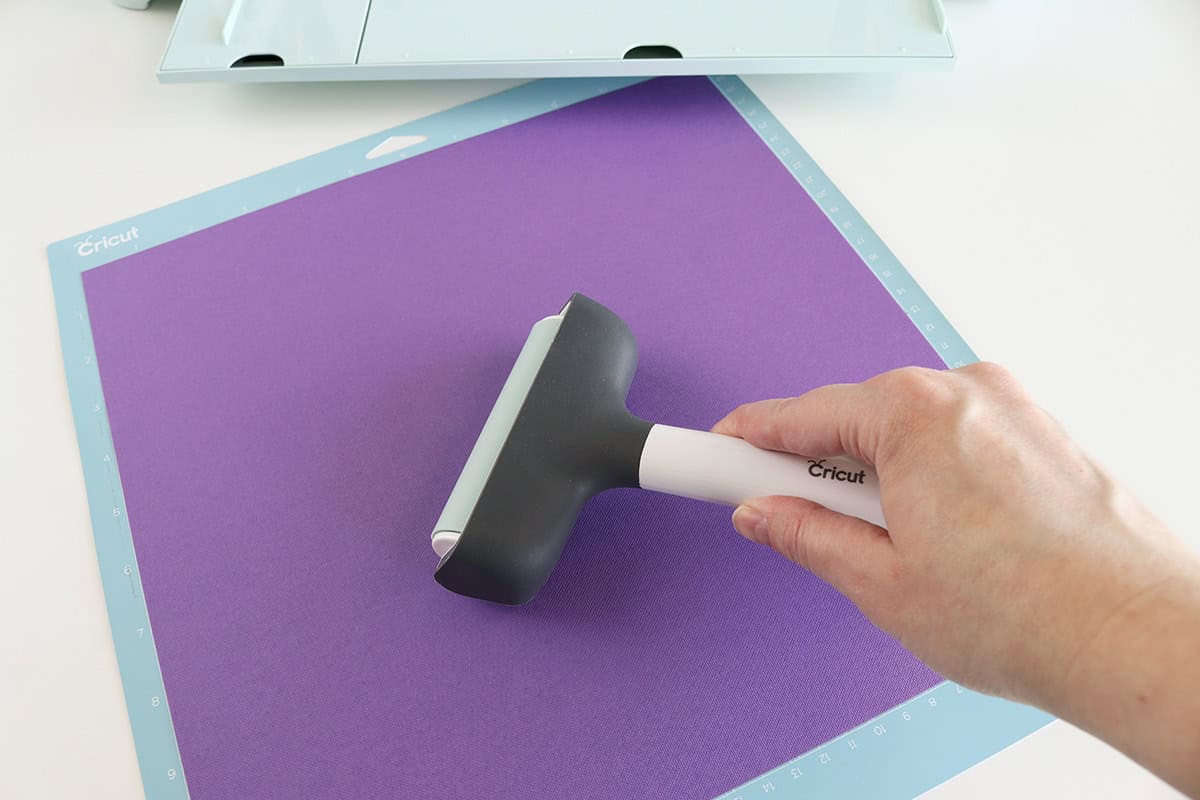 rolling brayer over Cricut mat to adhere cardstock well