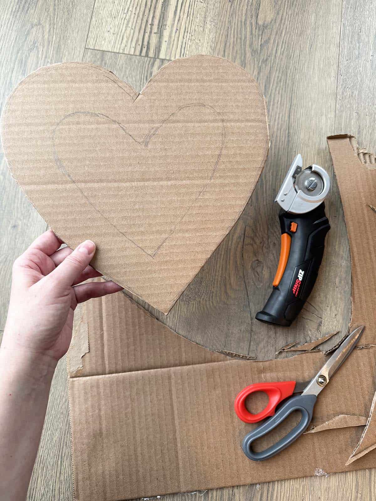 heart shaped piece of cardboard cut with cardboard cutters and scissors to make tissue paper heart shaped wreath for Valentine's Day