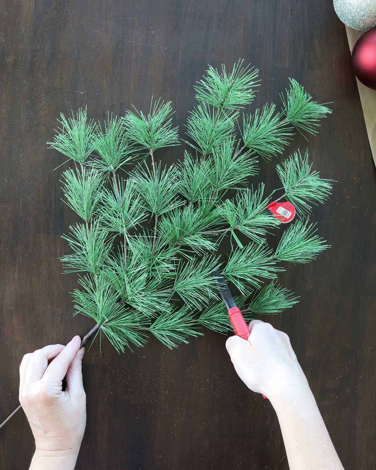 cutting Christmas greenery wreath pick into smaller pieces to fill in diy ornament wreath