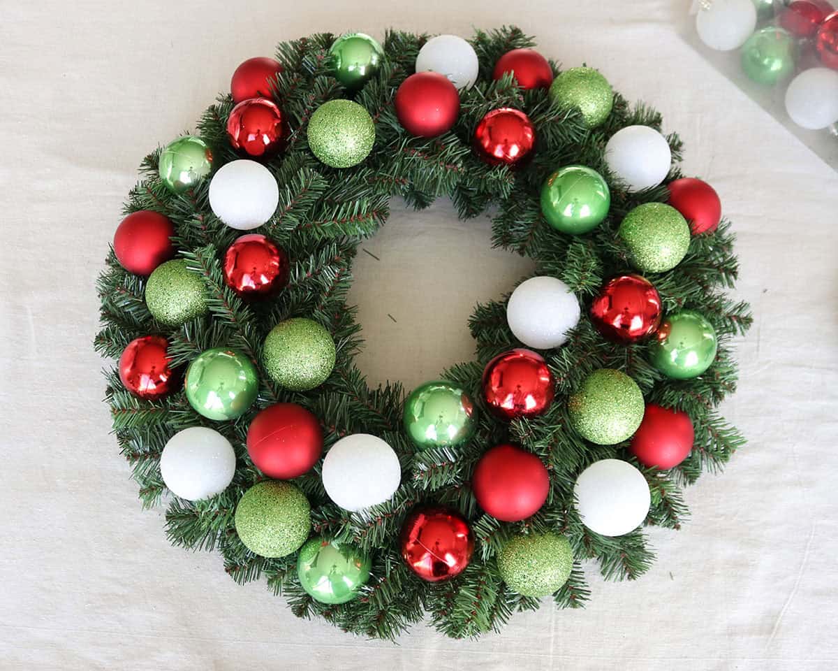 diy Christmas wreath for front door with ornaments using evergreen wreath form